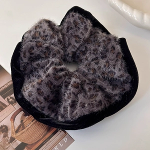 Detailed macro view of large leopard print plush hair tie with velvet edging texture