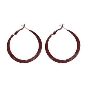 Macro detail of deep red enamel hoop earrings with a sleek metallic gradient design