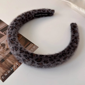 Detail view of plush faux fur leopard print headband with vintage handmade inner label