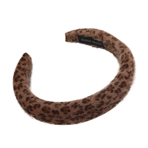 Detail of plush leopard print headband featuring a sewn Hand Made craft label inside