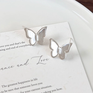 Detailed close-up of textured silver butterfly stud earrings on a white gift card
