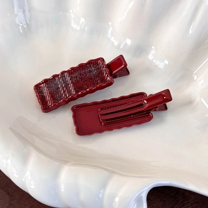 Détail de barrettes à carreaux rouges et bords ondulés sur une assiette blanche