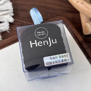 Detailopname van naadloze zwarte haarelastiekjes in een doosje met een blauw lint