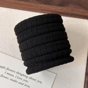 Detailopname van zwarte naadloze elastische haarelastiekjes met geribbelde textuur