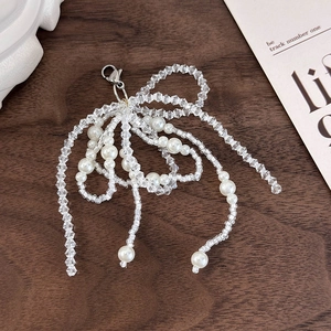 Detail showing handcrafted beaded bow shoe charm with pearls and silver lobster clasp