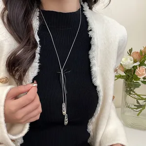 Ballerina bow pendant long sweater necklace worn on a white tweed jacket with roses