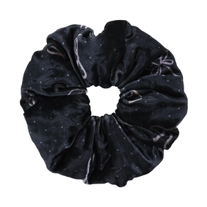 Elegant black velvet scrunchie with bow patterns and white polka dots for hair buns