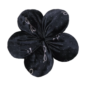Detail of floral black velvet scrunchie with white polka dots and bow patterns