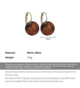 Dettaglio orecchini a sfera in ambra da 2cm in resina e lega dorata peso di 14g