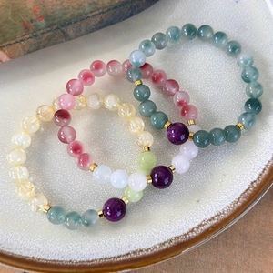 Three multi-colored beaded bracelets with natural stones and golden metal accents