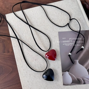 Detail of red and black heart pendant necklaces with adjustable long black cords