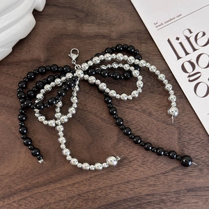 Detailed view of handmade black and silver beaded bow charm with lobster clasp attachment