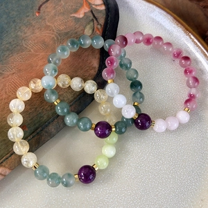 Close-up of handmade beaded bracelets featuring colorful natural stones and gold metal spacers