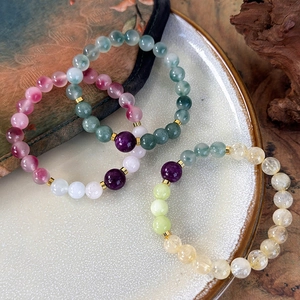 Ethnic style beaded bracelets with colorful natural stones and golden metal spacers in a tray