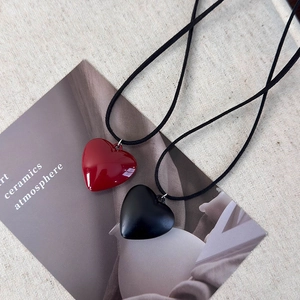 Adjustable cord necklace featuring vibrant red glossy and matte black heart pendants