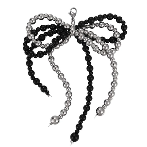 Handmade beaded bow shoe charm with black and silver beads and lobster clasp on white background