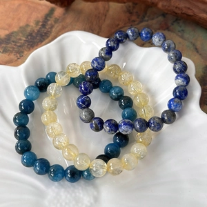 Three-piece natural stone bead bracelet set with lapis lazuli and citrine in a shell bowl