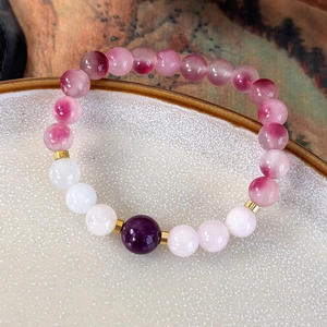 Detailed macro view of handmade beaded bracelet with pink and purple gradient gemstones