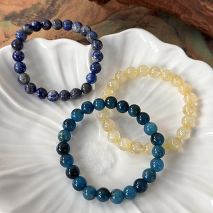 Natural lapis lazuli, citrine and apatite beaded bracelets in a decorative white ceramic tray