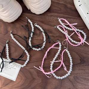 Détails de nœuds en ruban de ballet et charms de perles sur des baskets blanches