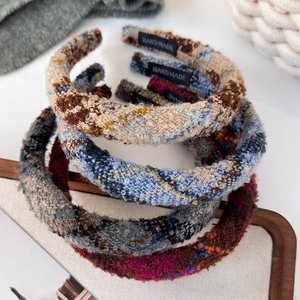 Close-up of thick tweed headbands in retro colors with handmade woven labels