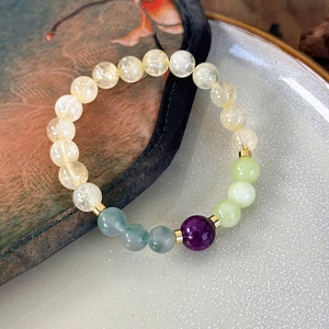 Detailed close-up of handmade colorful stone bead bracelet with golden metal spacers