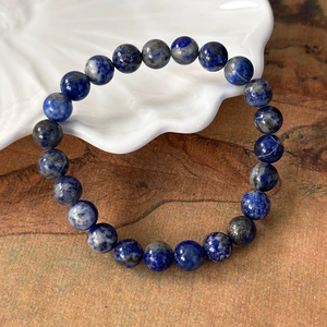 Macro detail of natural lapis lazuli beads with gold flecks on elastic bracelet