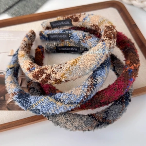 Close-up of handmade tweed headbands featuring vintage textures and luxury woven patterns