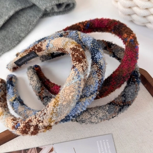 Close-up of handmade tweed headbands featuring retro plaid patterns and soft fabric texture