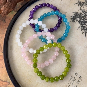 Macro shot of colorful beaded stone bracelets set of five displayed on a bamboo theme tray