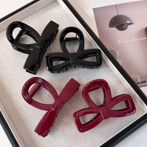 Elegant bow hair claws in black and burgundy resin with glossy finish and strong grip