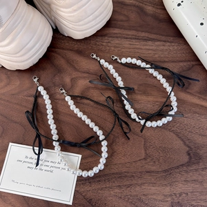 Vue détaillée des breloques de chaussures en perles avec nuds en ruban noir ballet