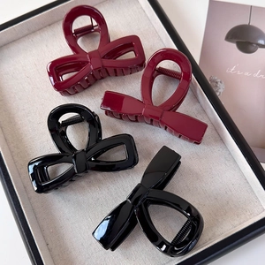 Elegant burgundy and black bow-knot hair claws in a minimalist resin style
