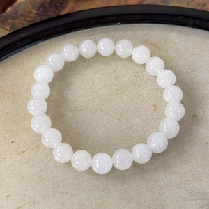 Detail showing smooth milky white round stone beads with a semi-transparent texture