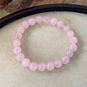 Detail of natural rose quartz beaded bracelet with polished 8mm pink translucent gemstones