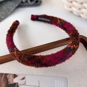 Detail of multi-color tweed headband texture with a black handmade fabric label