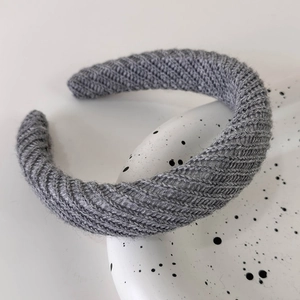 Close-up of grey knitted headband showing fine ribbed texture and soft fabric material