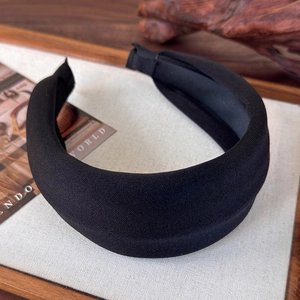 Detailansicht des breiten schwarzen gepolsterten Stirnbandes mit Stricktextur