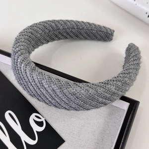 Detail of grey knitted padded headband showing thick yarn texture and 45-degree angle view
