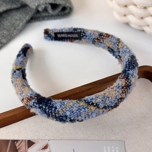 Detailed macro view of the handmade tweed fabric texture and woven label on a padded headband