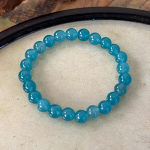 Detail view of handmade blue stone beaded bracelet with polished round translucent beads