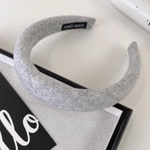 Detail of grey knitted padded headband featuring the authentic HAND MADE woven label inside