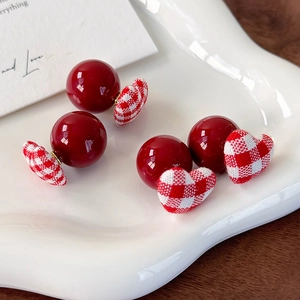 Retro red plaid heart fabric earrings with glossy beads on a white ceramic tray