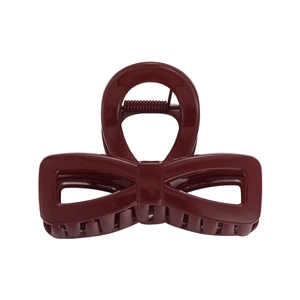 Deep red bow-shaped hair claw clip made of glossy resin with a secure metal spring