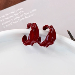 Elegant burgundy irregular pleated hoop earrings with polished metallic wave texture