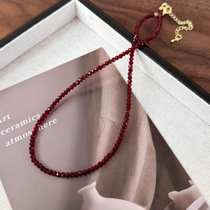 Close-up of deep red faceted bead necklace with gold-plated lobster clasp and extension