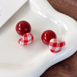 Close-up of red and white checkered fabric heart earrings with glossy red beads