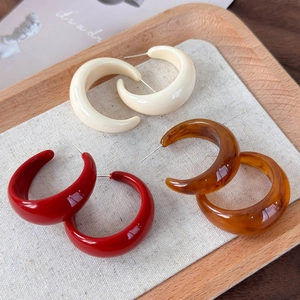 Trois paires de boucles d'oreilles créoles C en résine crème, rouge et couleur ambre