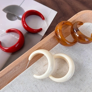 Trois paires de boucles d'oreilles créoles C en résine rouge, ambre et blanc crème
