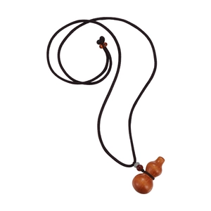 Vue macro d'un pendentif gourde en bois sculpté avec un collier en corde tressée marron
